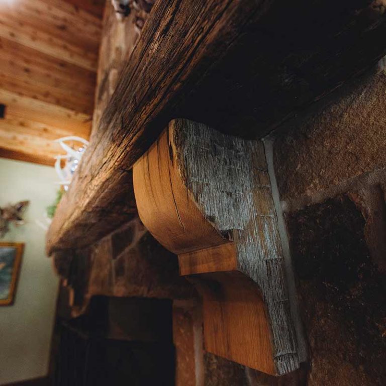 Rustic wooden fireplace mantel detail.