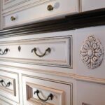 Antique white dresser with ornate details.